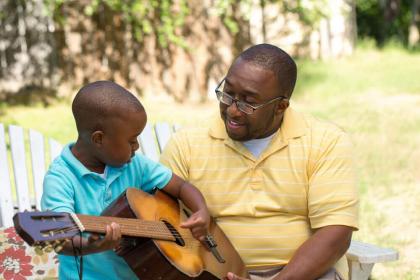 Father and son playing guitar